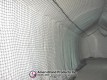Lengthwise view of the netted batting lane inside a pitching dome
