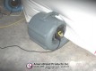 Portable blower inflating the white pitching dome