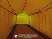 Netted batting lane inside a yellow-lit pitching dome