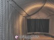 Netted pitching lane leading to a dark impact screen