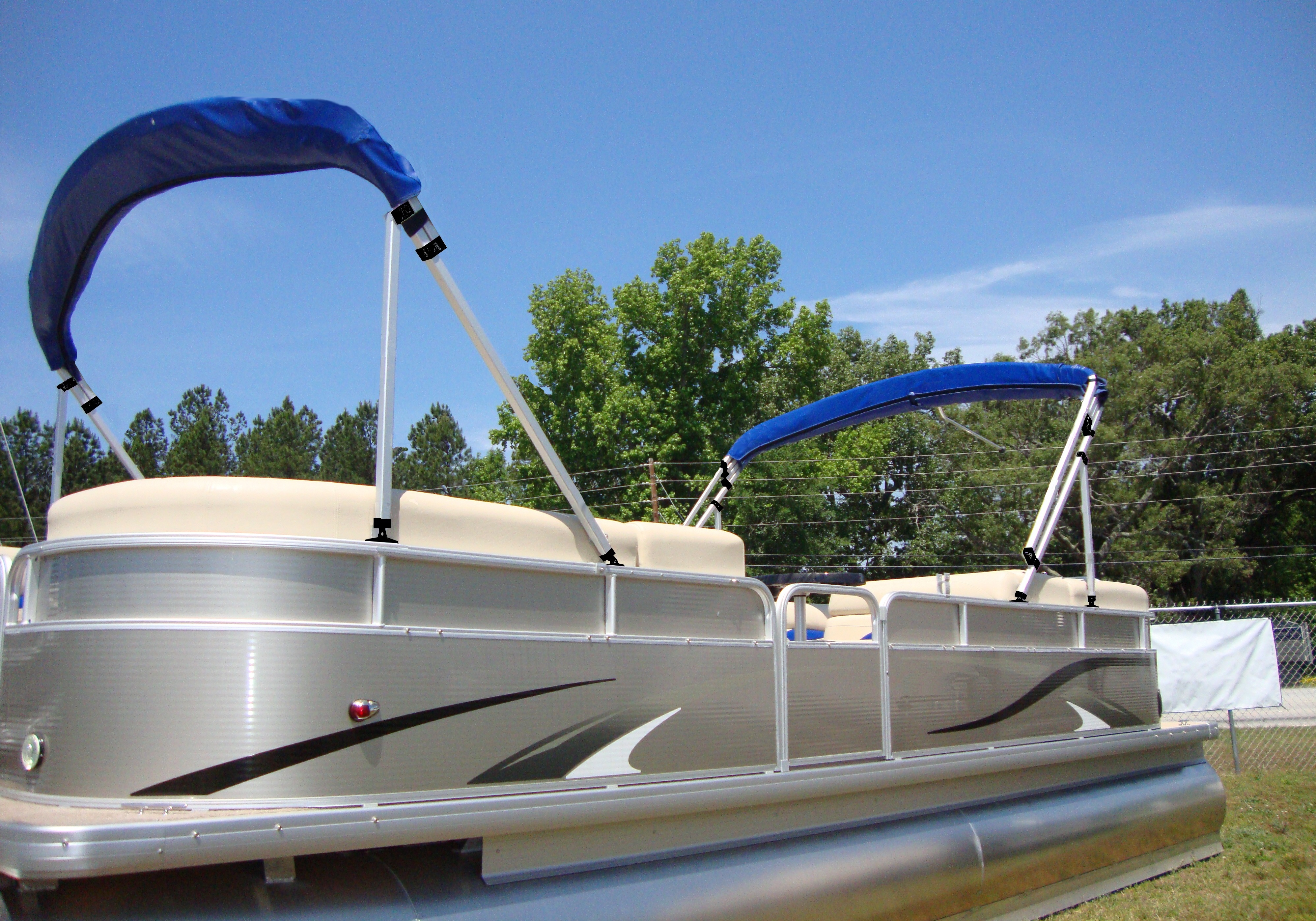Blue dual pontoon bimini top stored on brace kits