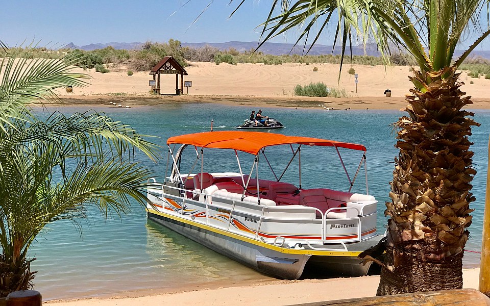 Orange dual pontoon bimini top installed on a Playcraft Powertoon