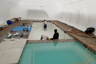 Construction Dome - Inside view of workers touching up plaster.