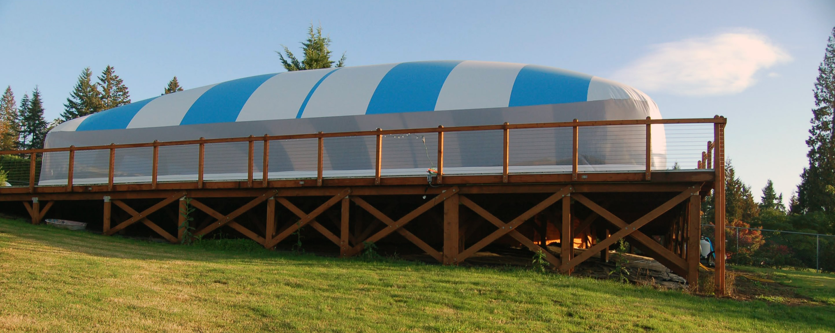 Blue and white Ameri-Dome installed over an elevated swimming pool deck