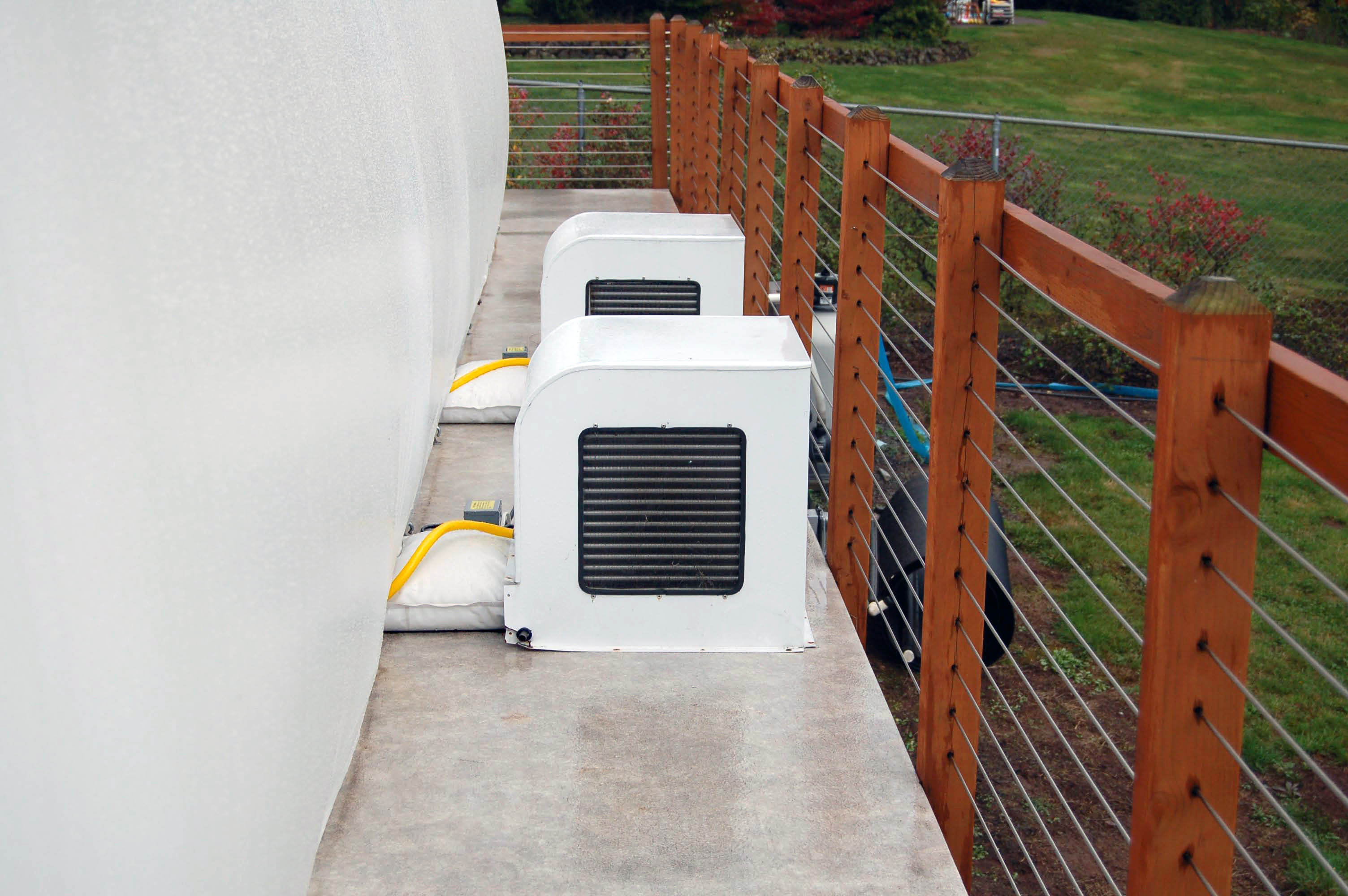 Two Ameri-Dome heater and dehumidifier units installed beside a pool dome