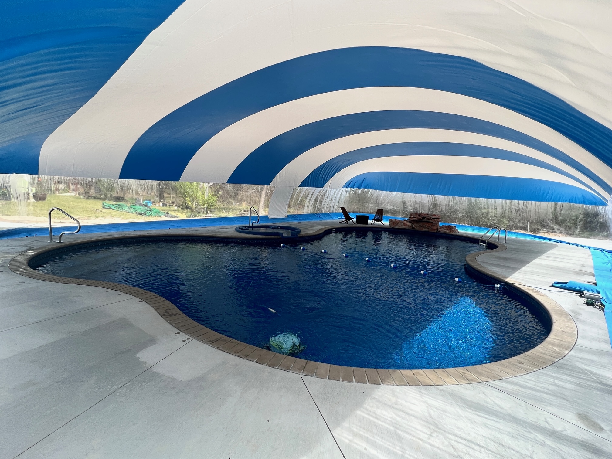 Interior of a blue and white Ameri-Dome enclosing a residential swimming pool