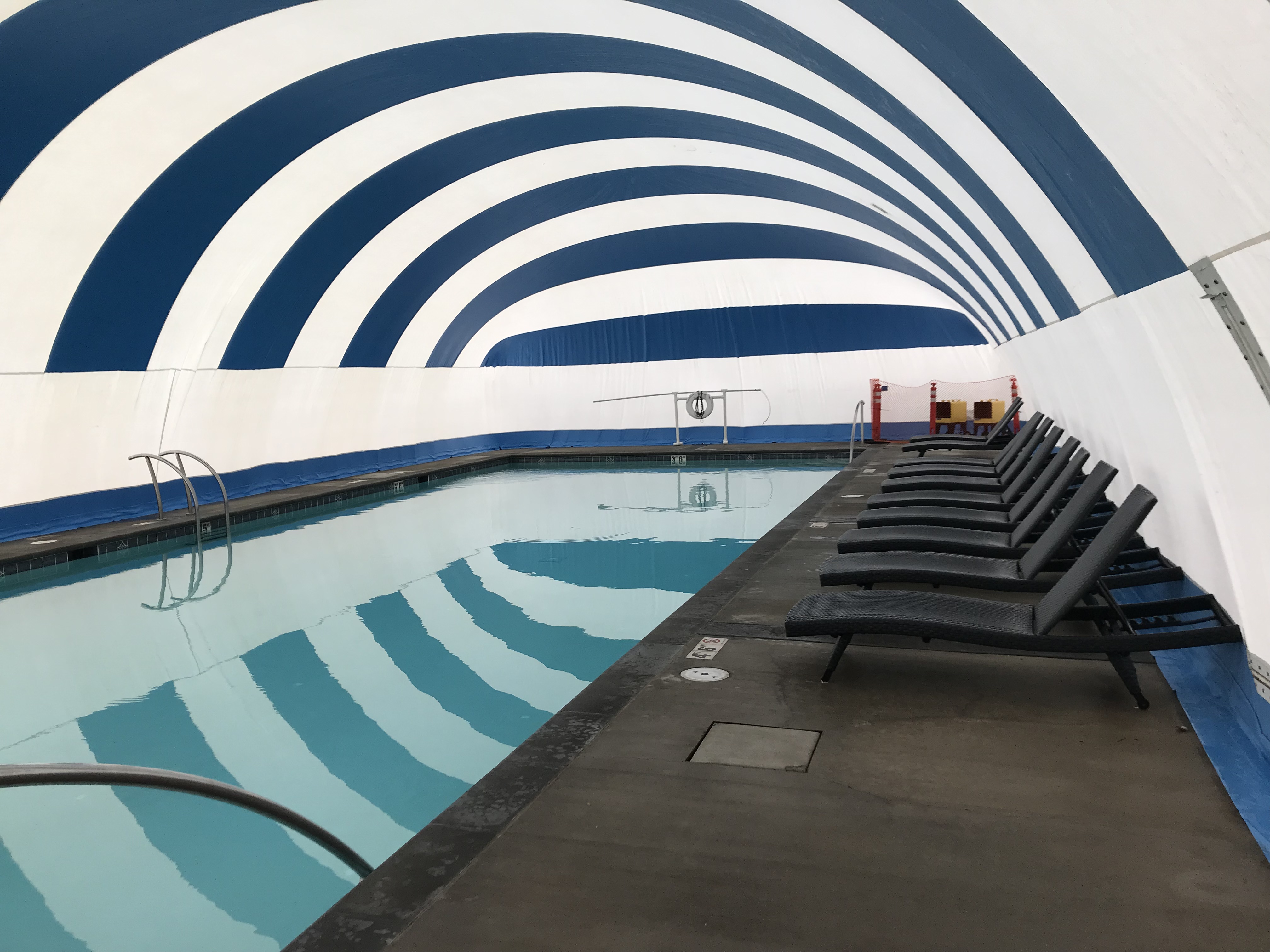 Pool edge and surrounding deck inside a blue and white Ameri-Dome