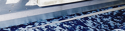 Two pieces of patterned vinyl overlapping under a welding bar