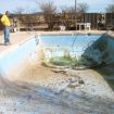 The pool is drained showing damage and scope of project.