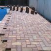 Picture shows remaking of deck. Pavers installed along perimeter of pool to clean up appearance of pool deck.