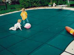 Children playing on safety pool cover